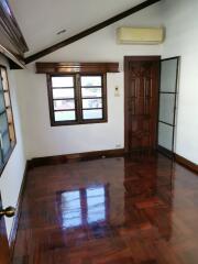 Empty bedroom with wooden flooring and large windows