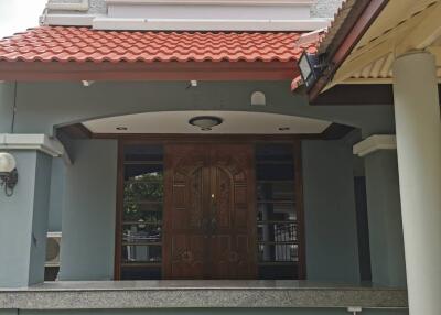 Front entrance of the house with large decorative double doors and tiled roof