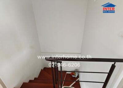 Interior staircase with wooden steps and white walls