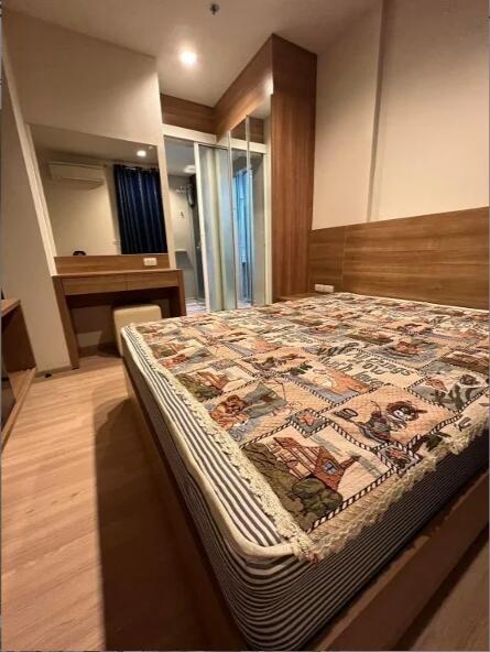 Well-lit bedroom with a double bed, wooden floor, and a large mirror wardrobe