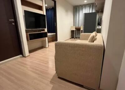 Living room with beige sofa and TV unit, view towards dining area