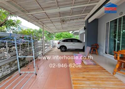 Covered outdoor area with a parked car, patio furniture, and laundry drying racks