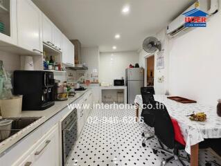 Modern kitchen with white cabinetry and dining area