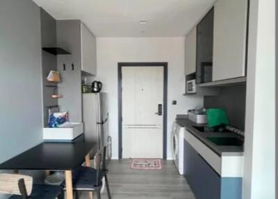 Modern kitchen with black and white cabinetry and light wood flooring