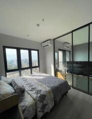 Modern bedroom with large windows and a city view