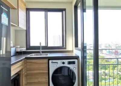 Modern kitchen with washing machine and balcony view