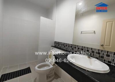 Modern bathroom with tiled walls and large mirror