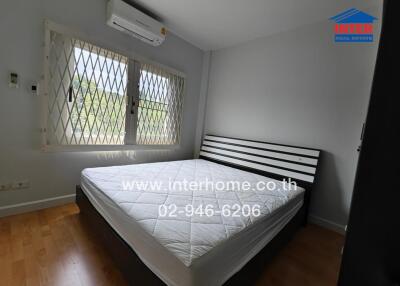 Bedroom with bed, window with grill, and air conditioner