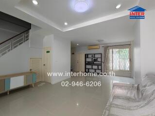 Spacious living room with modern lighting and a staircase.