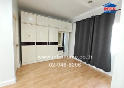 Spacious bedroom with large wardrobe and wooden flooring