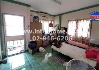 Bedroom with green tile floor, bed, and various clutter