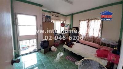 Bedroom with green tile floor, bed, and various clutter