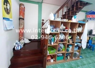 Interior of a building showing stairs, storage, and various household items