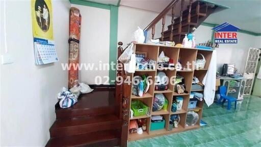 Interior of a building showing stairs, storage, and various household items