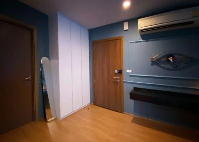 Entryway with wooden floor, wall-mounted air conditioner, mirror, and decorative wall art