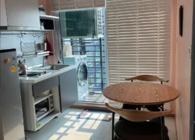 A modern kitchen with dining area, equipped with appliances.