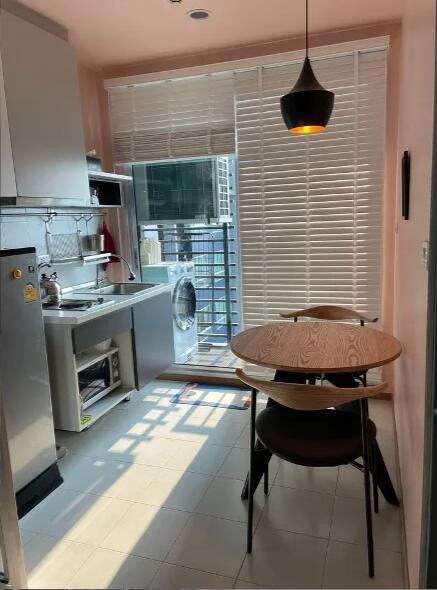 A modern kitchen with dining area, equipped with appliances.