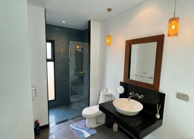 Modern bathroom with glass shower, sink, and toilet