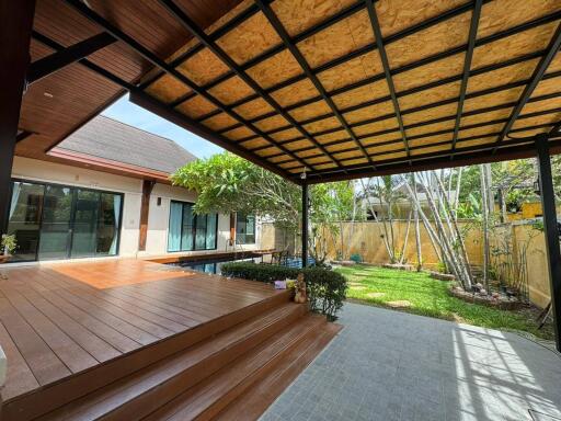 Covered patio with wooden deck and garden view