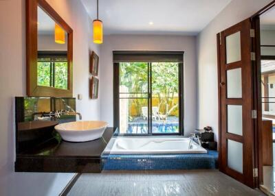 Modern bathroom with a large window, bathtub, and stylish sink.