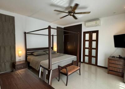 Spacious bedroom with a four-poster bed, work desk, and modern amenities