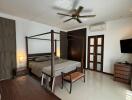 Spacious bedroom with a four-poster bed, work desk, and modern amenities