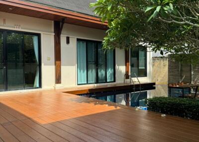 Beautiful outdoor deck with pool and lush greenery