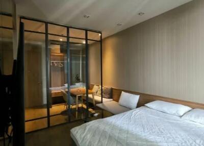 Modern bedroom with glass partition and cozy seating area