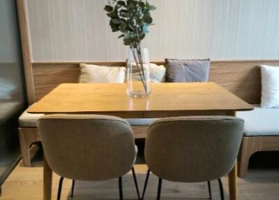 Dining area with wooden table and two cushioned chairs