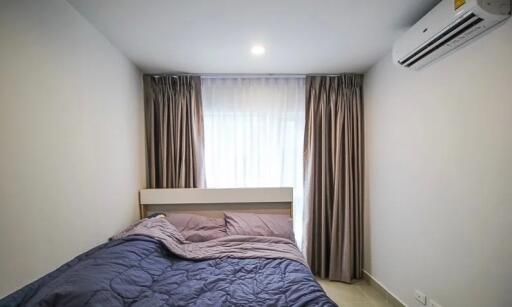 Cozy bedroom with a bed, window, and air conditioning unit