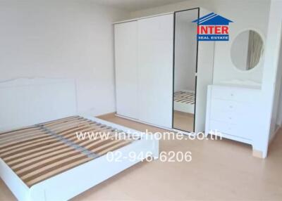 Spacious bedroom with modern white furniture and built-in wardrobe
