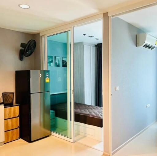 Modern apartment with a small bedroom, visible refrigerator, and air conditioning