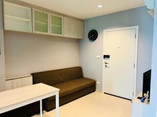 Living room with couch, wall cabinet and clock