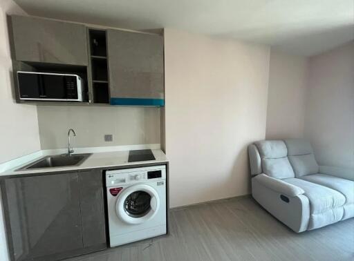 Modern small kitchen with appliances and a lounge chair