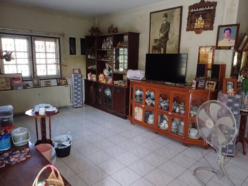 A well-lived in living room with various decorations, a television, and a fan.