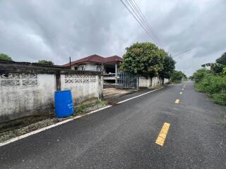 Front view of a house with a road and gate