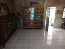 Living room with tile flooring and glass-front cabinets