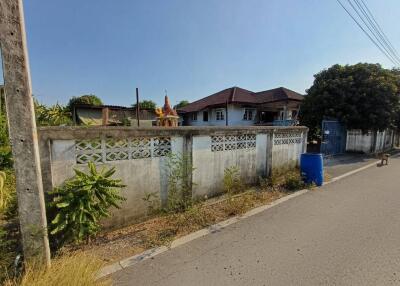 Exterior view of a house with a front yard and boundary wall