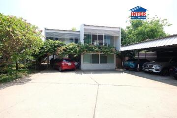 Front view of a residential building with multiple cars parked in driveway