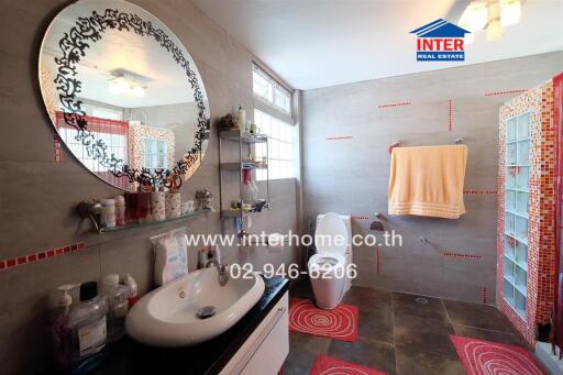 Modern and stylish bathroom with a decorative mirror, sink, and a shower area