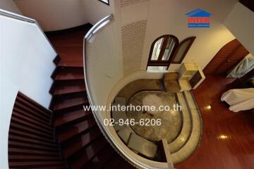 Aerial view of a living room with hardwood floors and a staircase