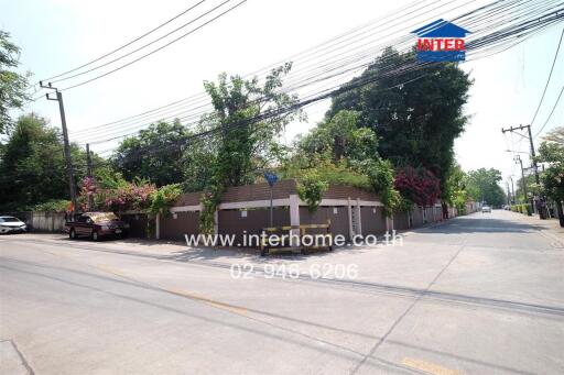 Exterior view of a building with a surrounding fence and greenery