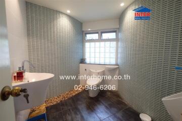 Modern bathroom with ceramic tiles and natural pebble accents