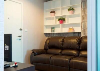 Cozy living room with a brown leather sofa and shelving