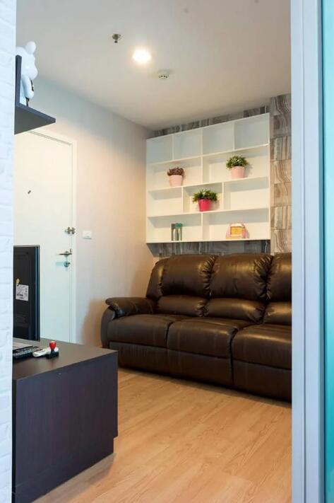 Cozy living room with a brown leather sofa and shelving