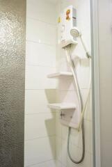 Bathroom shower area with electric water heater and showerhead