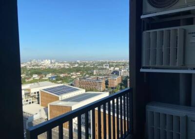 Balcony view overlooking cityscape with air conditioning units