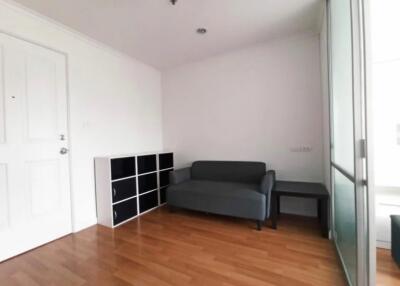 small living room with wooden floor, couch, storage unit, and glass sliding door