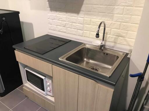 Compact kitchen with sink, microwave, and cooktop