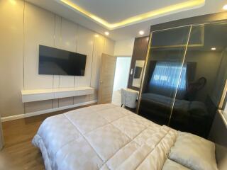 Modern bedroom with mounted TV and sleek furnishings